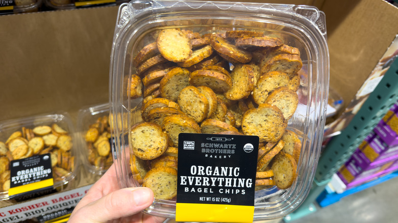 hand holding a plastic container of bagel chips from Costco