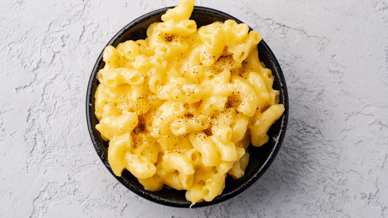 Delicious mac and cheese in a bowl on grey stone background