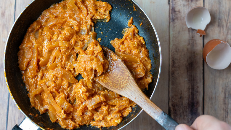 scrambled eggs being cooked in a pan