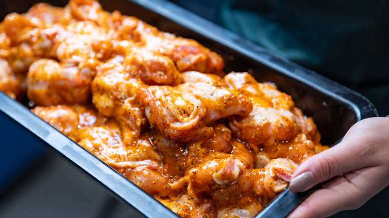 A tray of raw, marinated chicken meat is seen on display