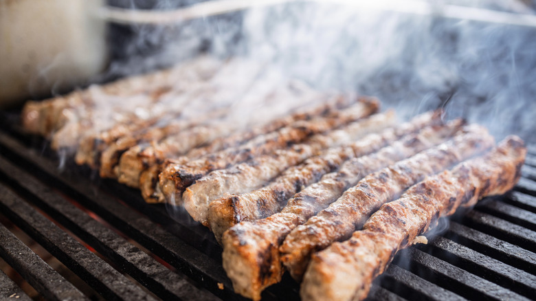 Kebabs roasting and smoking on a grill