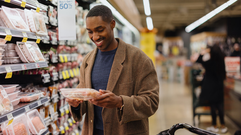 Man looking at meat in a supermarket