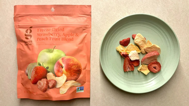 A bag  and a plateful of Good & Gather Apple, Strawberry, and Peach Freeze Dried Fruit Blend on a table