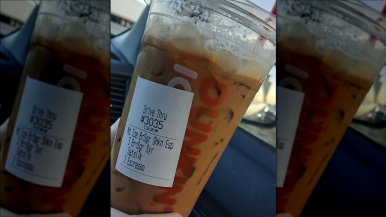 Dunkin' Tiramisu Shakin' Espresso held by someone in their car.