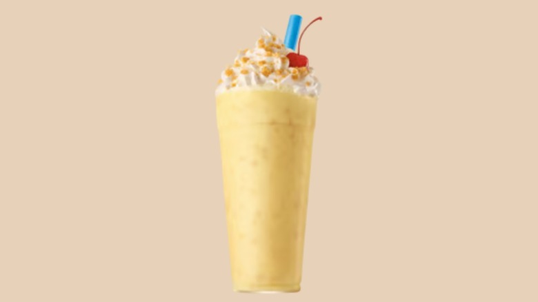 Sonic Banana Pudding Shake in a glass on a pale orange background.