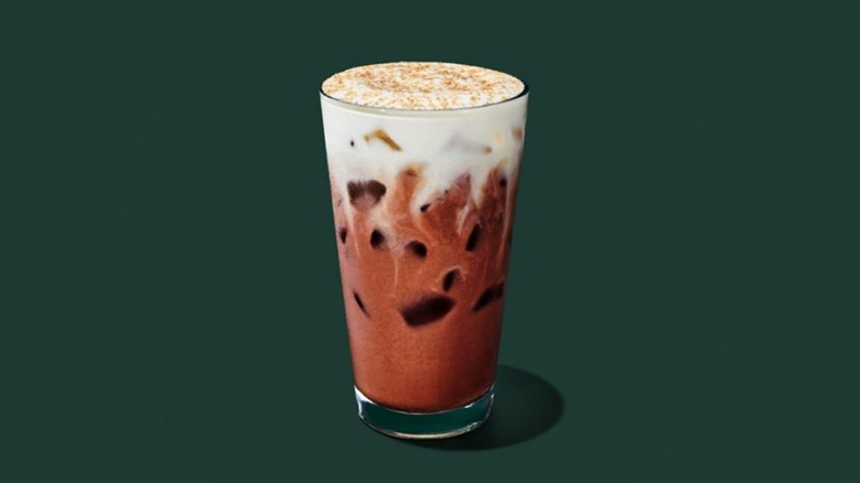 Starbucks Iced Dubai Chocolate Mocha product image sitting on a forest green background.