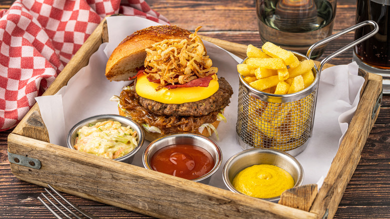 Western burger is on a tray with fries.