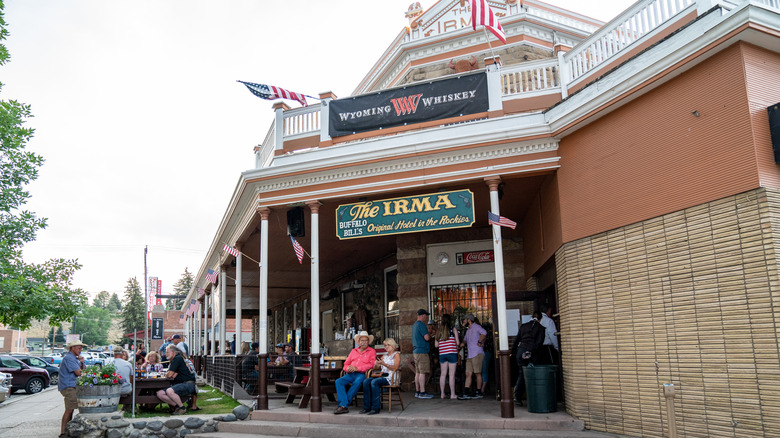 People stand on the front porch of the Irma hotel.