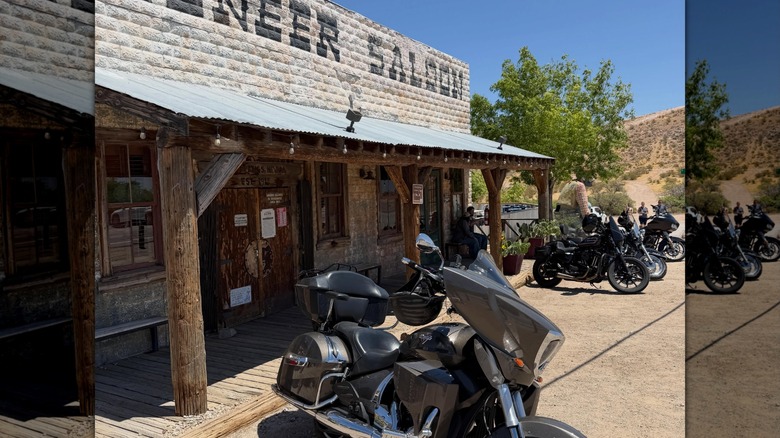 Motorcycles are parked outside of The Pioneer Saloon.