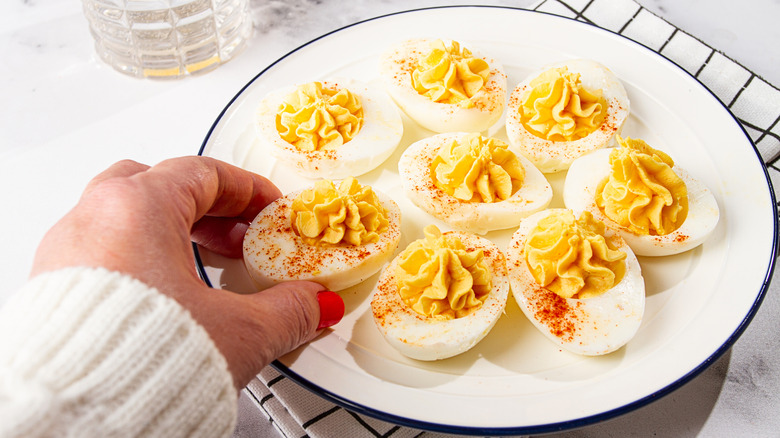 hand reaching for deviled eggs