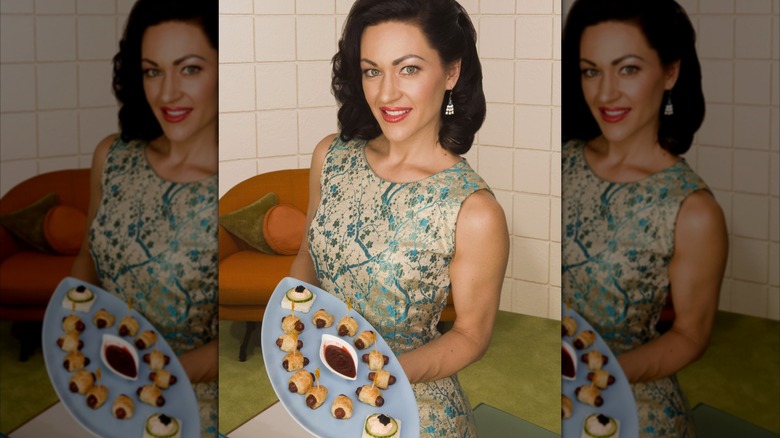 A retro woman holding a platter of pigs in a blanket, mirrored