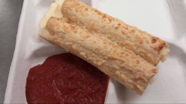 Italian dunkers school cafeteria breadsticks with side of marinara sauce for dunking