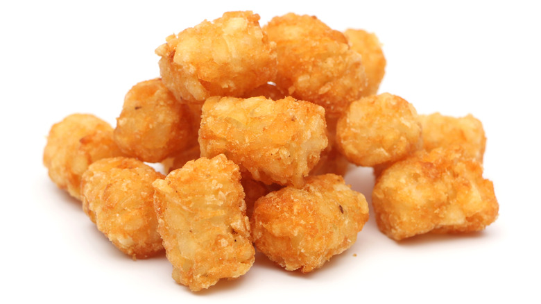 Tater tots in a containter on a white background