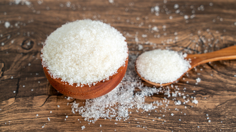 sugar in small wooden bowl and over wooden spoon
