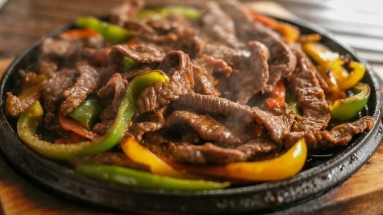 a plate of beef fajitas with vegetables