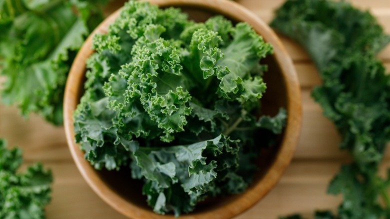 a wooden bowl filled with kale