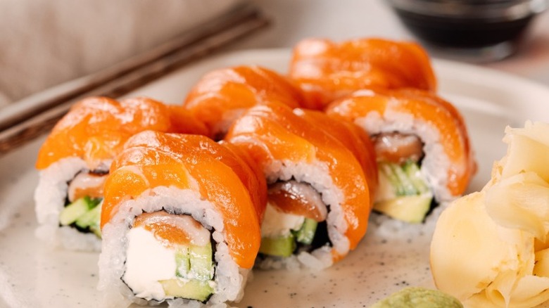 sushi rolls topped with salmon with ginger and wasabi