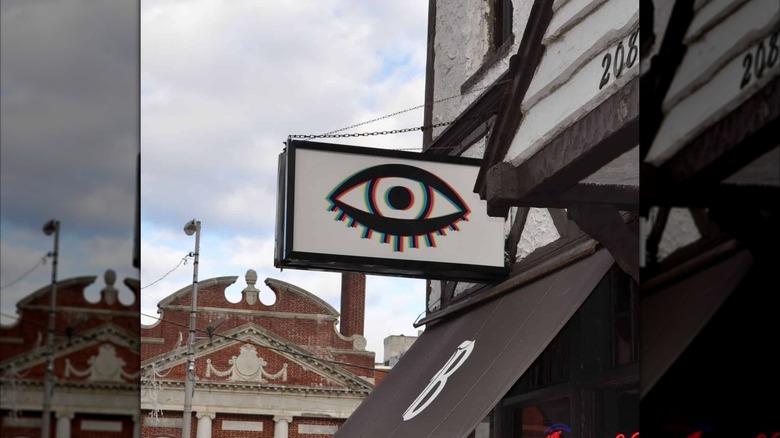 Exterior shot of Bond Street Bar with sign with awnings and sign that has bar's eyeball logo