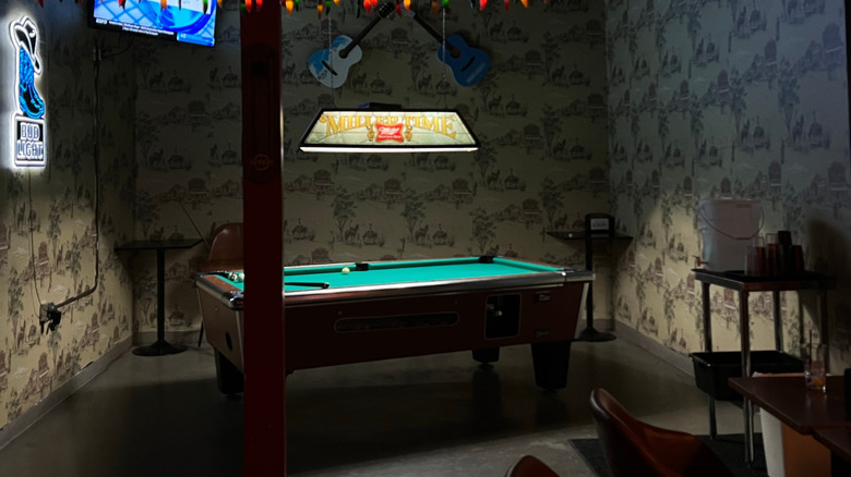 Darkly lit pool table in a dive bar