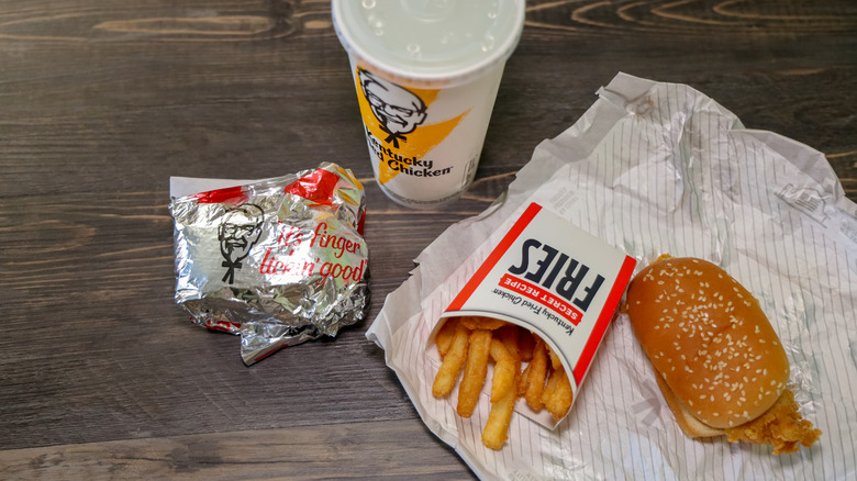 KFC mini chicken sandwich with fries on a wooden table