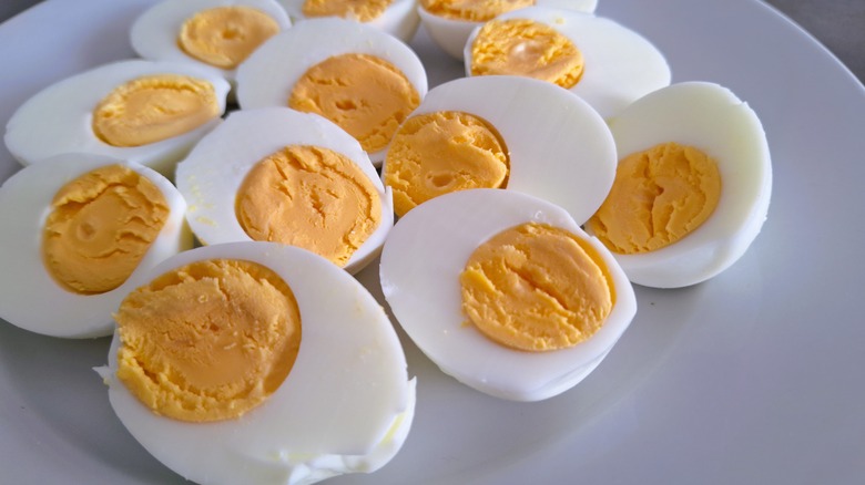 Hardboiled eggs cut in a half on a white plate