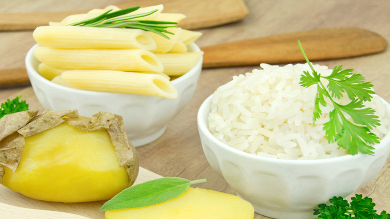Cooked pasta and rice in white bowls