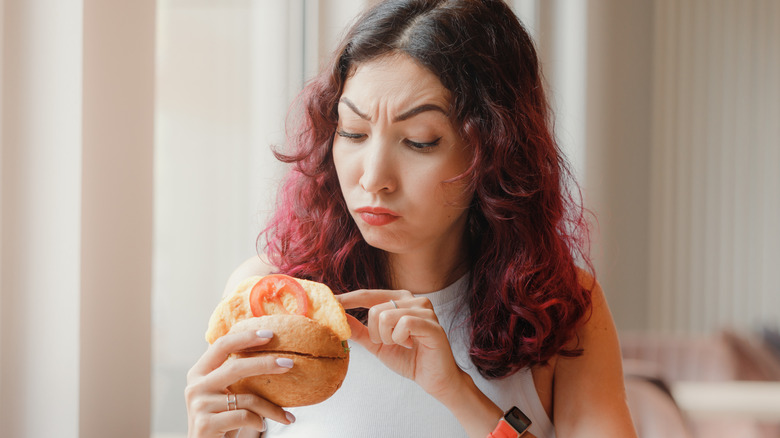 A woman looking suspiciously at her food
