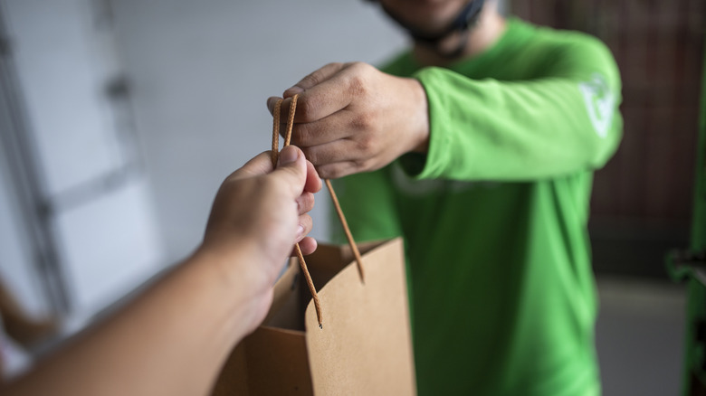 Delivery driver handing food to a customer