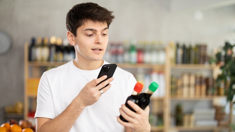 Man inspecting the label on soy sauce