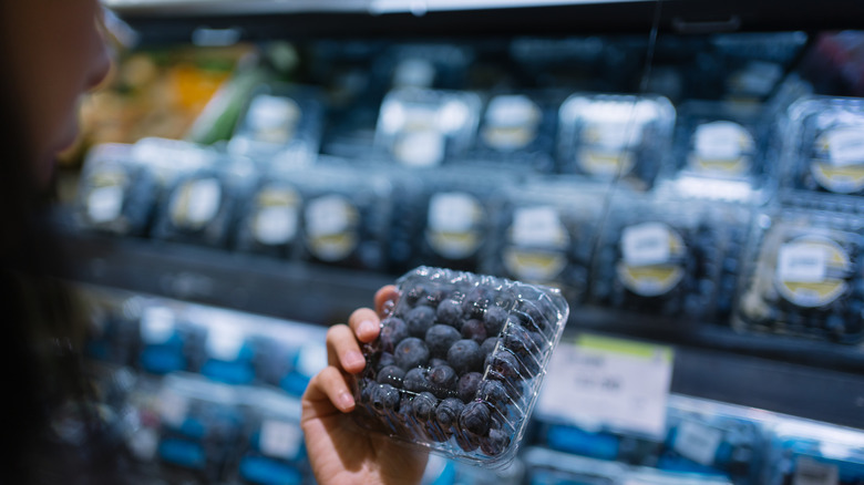 Person looking at a container of blueberries