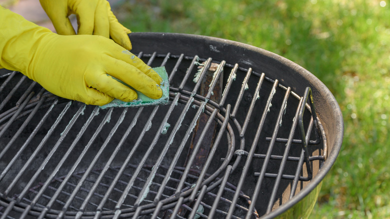 Person cleaning dirty grill grates