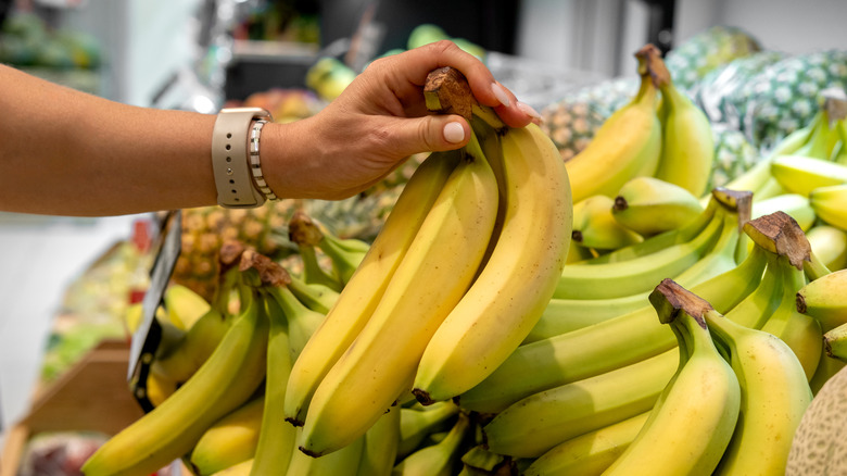 Person holding bananas in a store