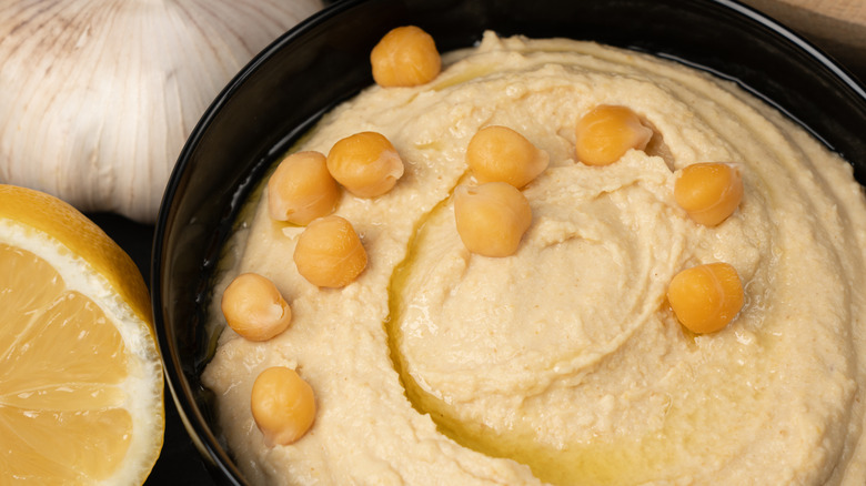 Bowl of hummus with a drizzle of oil and chickpeas on top