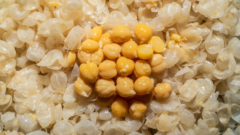 A small pile of cooked chickpeas resting on a bed of peeled skins