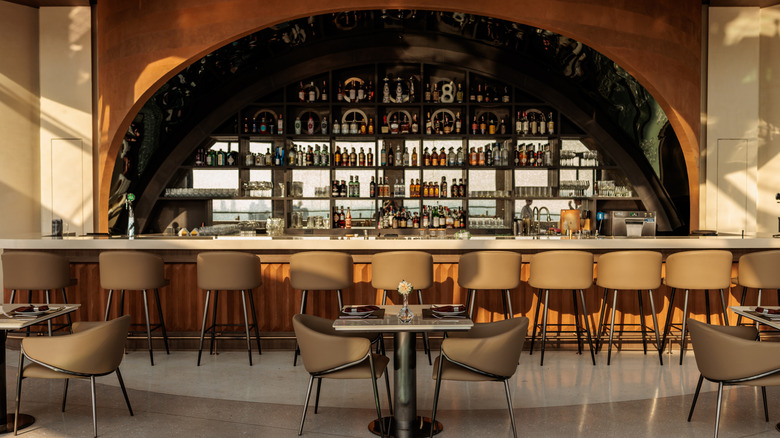 Tan stools line an empty bar.