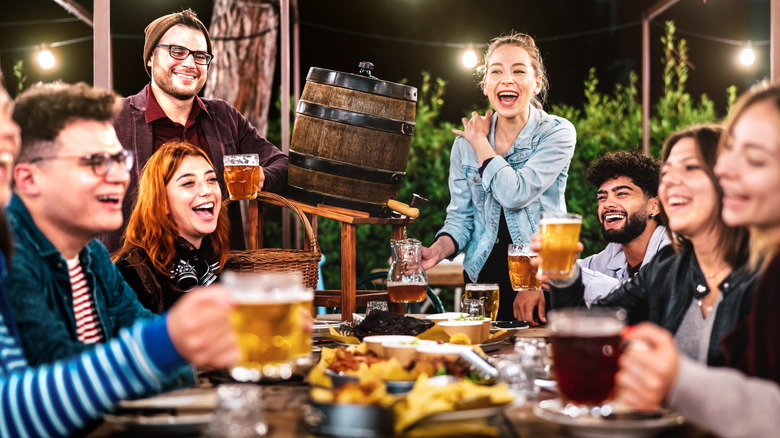 Group of friends laughing and having fun while holding beers.
