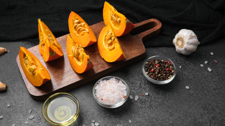 Slices of pumpkin next to salt, pepper, and oil