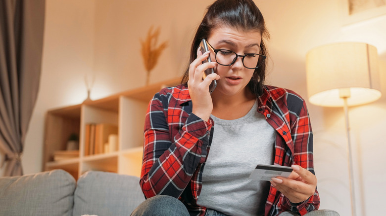 A woman ordering takeout over the phone from the living room