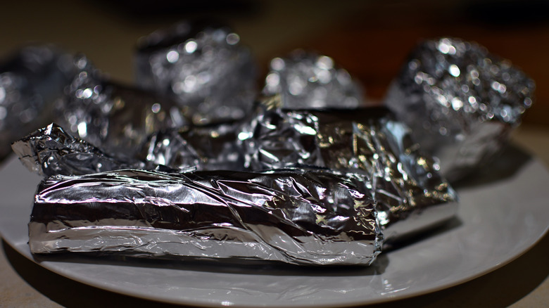 Vegetables wrapped in aluminium foil background