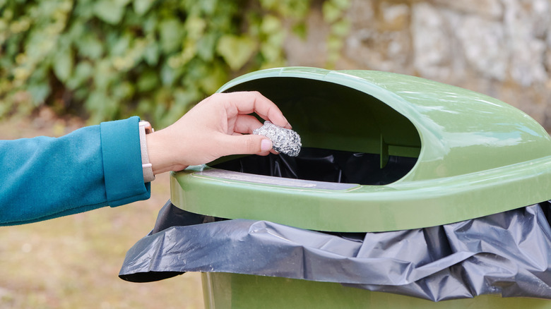 Disposing of crumpled aluminum foil in a trash bin