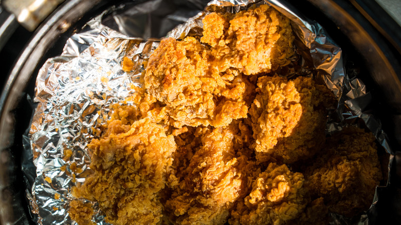 Heating a fried chicken on a airfryer at home. Simple cooking without oil with airfryer and aluminum foil