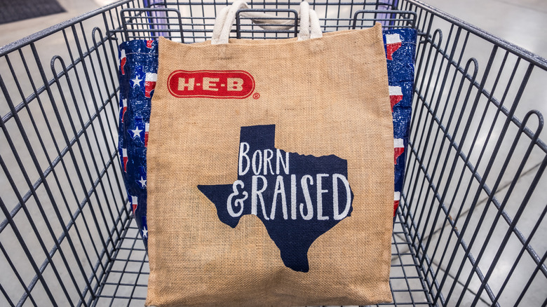 An H-E-B reusable bag in a shopping cart
