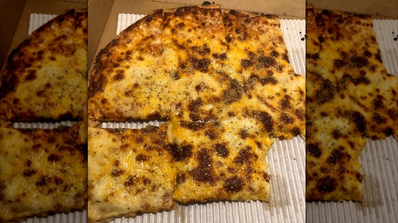 About half of a Casey's four cheese pizza in its box.