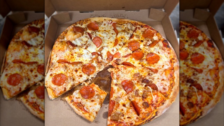 A Casey's sweet heat and pepperoni pizza in its box with one slice half eaten.