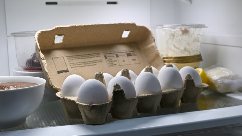 Open carton of eggs on fridge shelf