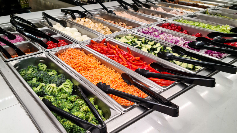self service salad bar with trays of pre-cut vegetables