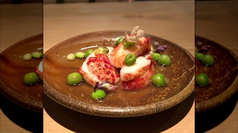 Raw seafood dish on brown plate at Naoe