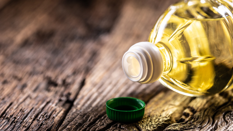 Bottle of cooking oil laying down with open lid