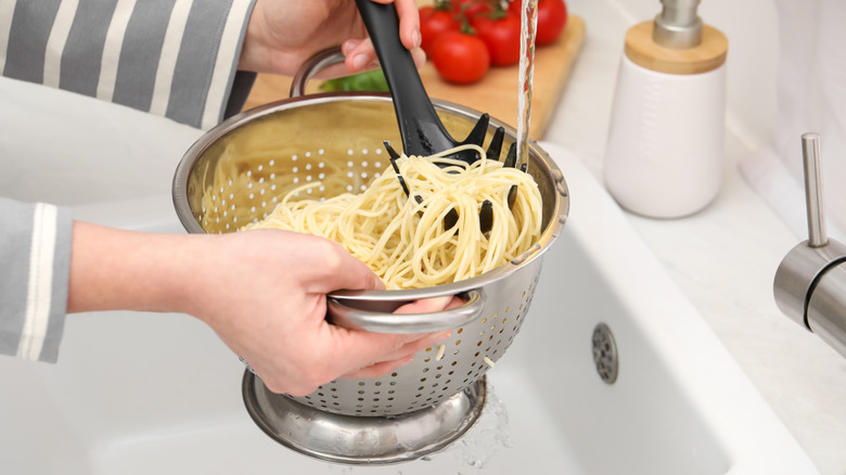 Person rinsing cooked pasta
