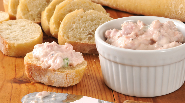 Ham salad on a wooden table with sliced baguette